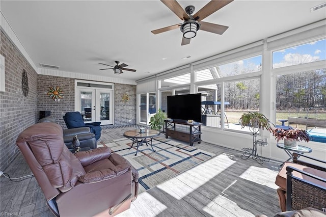 sunroom / solarium featuring visible vents, a fireplace, and a ceiling fan