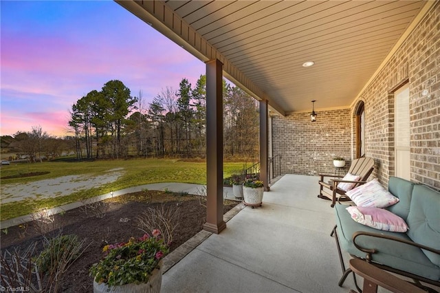 patio terrace at dusk featuring a yard