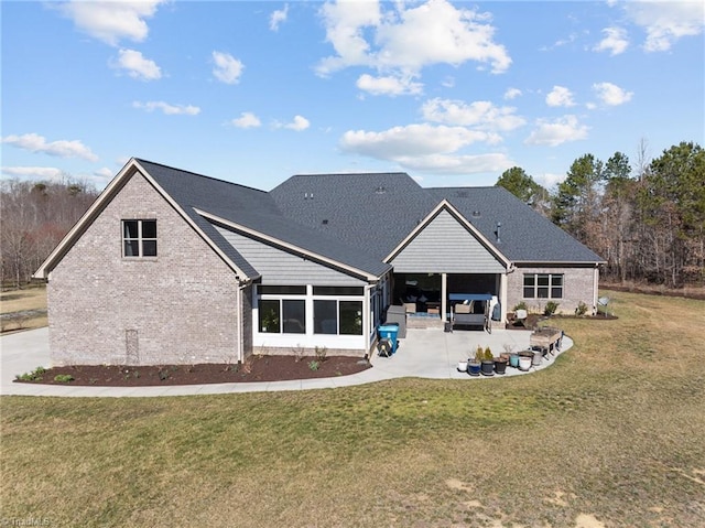 back of house featuring an outdoor living space, a yard, a patio, and brick siding