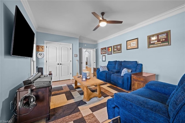 living area with ornamental molding and ceiling fan