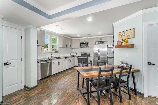 525 Carolina Blvd, Salisbury, NC 28146 - kitchen with appliances with stainless steel finishes, backsplash, dark wood-style flooring, ornamental molding, and gray cabinetry