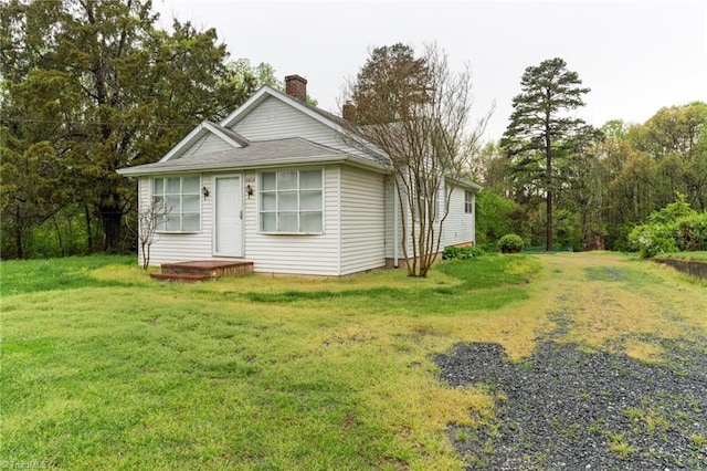 view of front facade featuring a front lawn and a chimney