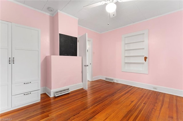 unfurnished bedroom featuring crown molding, wood finished floors, baseboards, and a ceiling fan