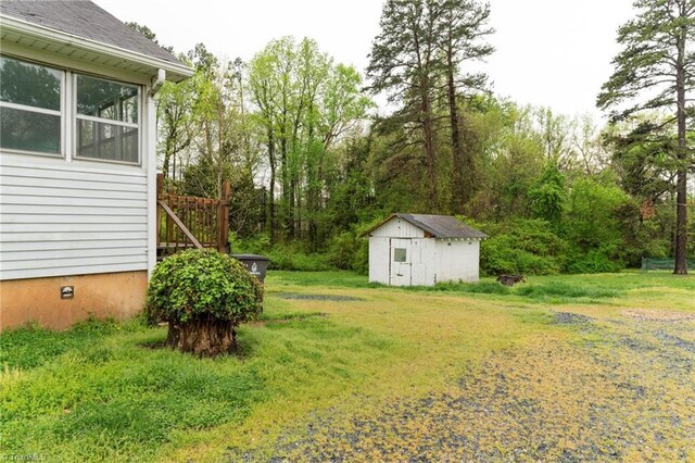 view of yard featuring a storage shed and an outbuilding