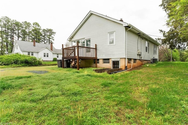 back of house featuring a wooden deck, cooling unit, and a lawn
