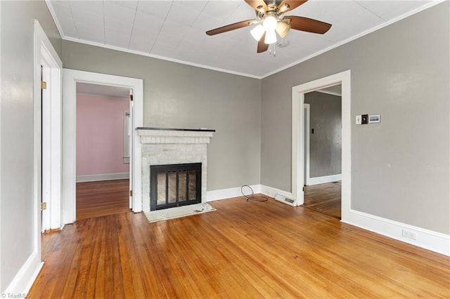 unfurnished living room featuring crown molding, visible vents, a ceiling fan, and a brick fireplace