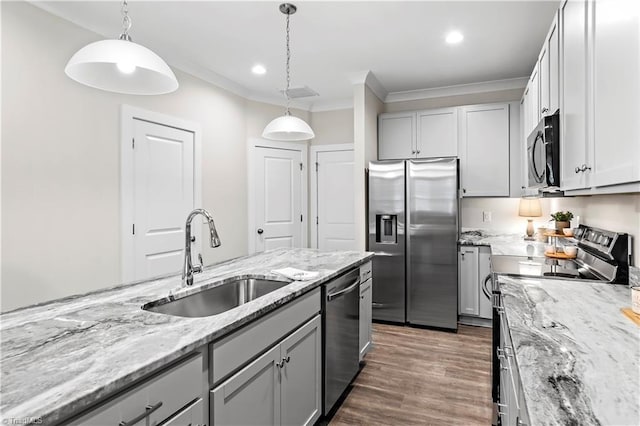kitchen featuring stainless steel appliances, a sink, crown molding, hanging light fixtures, and gray cabinetry