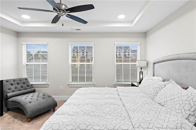 bedroom featuring a raised ceiling, carpet flooring, baseboards, recessed lighting, and ceiling fan