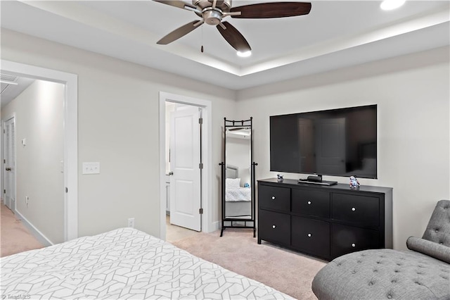 bedroom with light colored carpet, attic access, baseboards, ceiling fan, and a raised ceiling