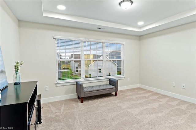 sitting room with a raised ceiling, baseboards, light colored carpet, and recessed lighting