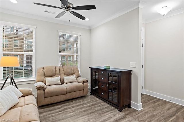 living area featuring wood finished floors, crown molding, a ceiling fan, healthy amount of natural light, and recessed lighting