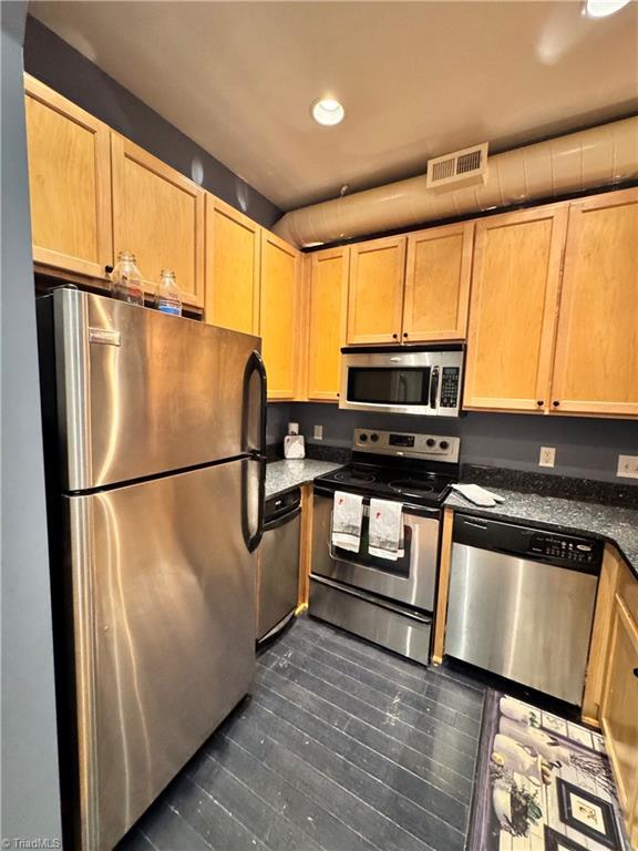220 Market St Unit 110, Greensboro, NC 27401 - kitchen featuring stainless steel appliances, recessed lighting, light brown cabinetry, and dark stone counters