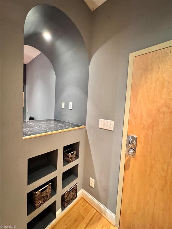 220 Market St Unit 110, Greensboro, NC 27401 - hall with wood finished floors, arched walkways, and baseboards