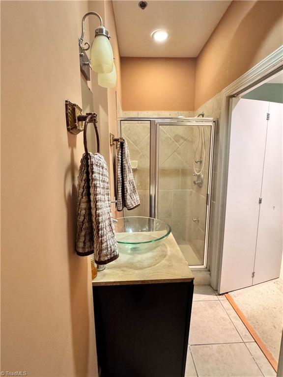 220 Market St Unit 110, Greensboro, NC 27401 - bathroom with a stall shower, tile patterned floors, and vanity