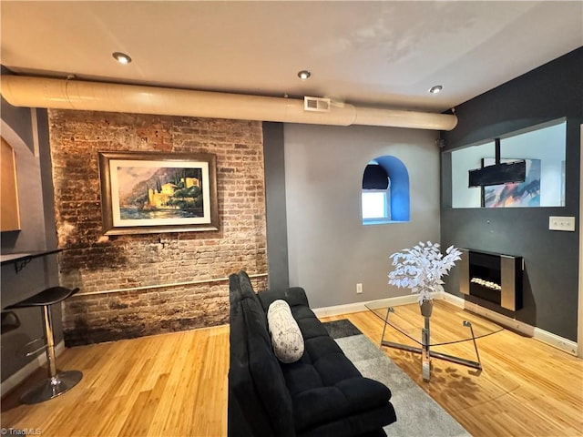 220 Market St Unit 110, Greensboro, NC 27401 - living area with wood finished floors, baseboards, brick wall, and recessed lighting