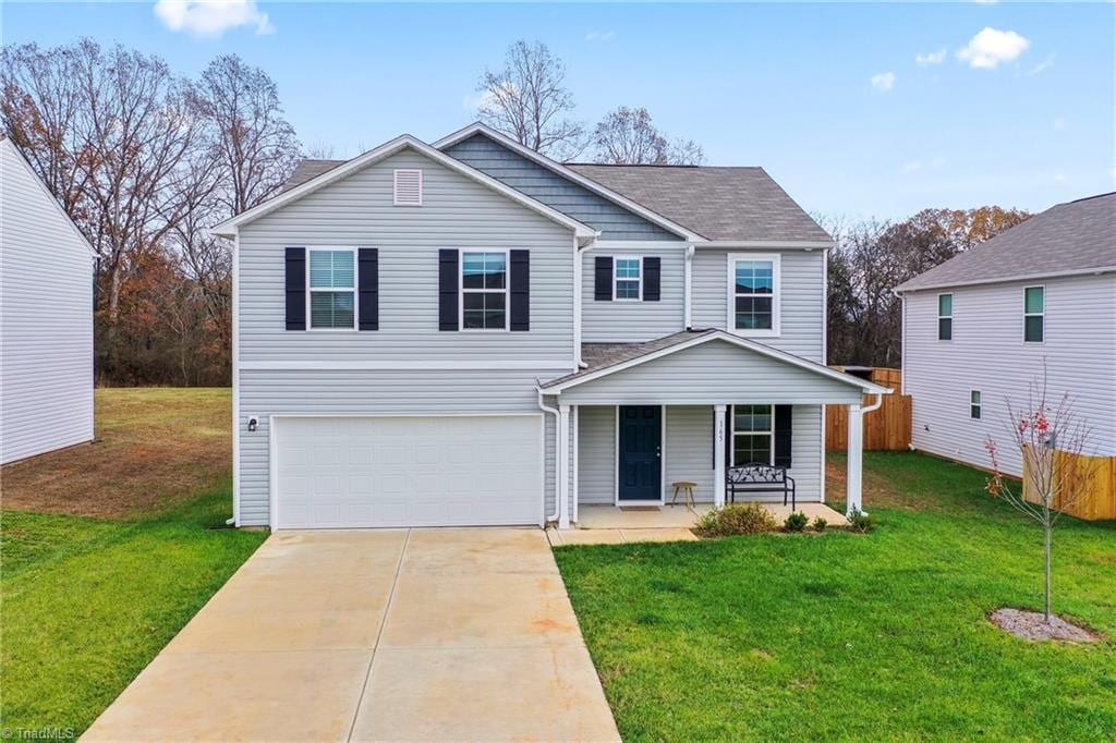 front of property with a front lawn, a porch, and a garage