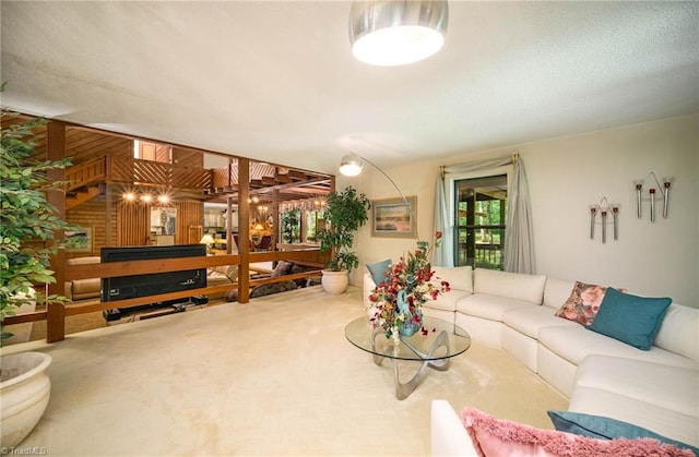 carpeted living room featuring an inviting chandelier