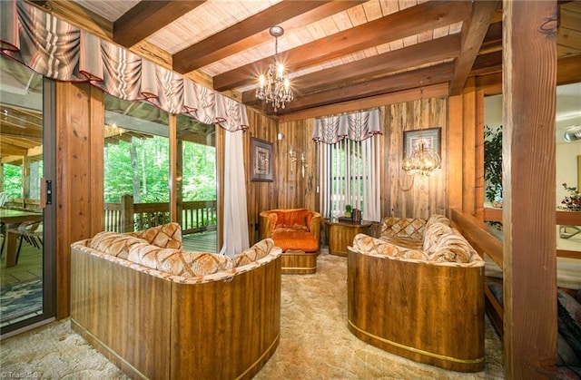 interior space with an inviting chandelier, beam ceiling, a wealth of natural light, and wood walls