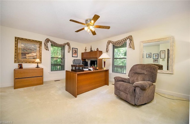 carpeted office space with ceiling fan