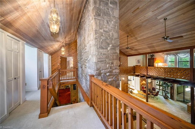 hall featuring light carpet, wood ceiling, and vaulted ceiling