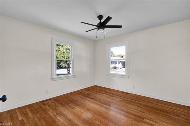 unfurnished room with wood-type flooring, a healthy amount of sunlight, and ceiling fan