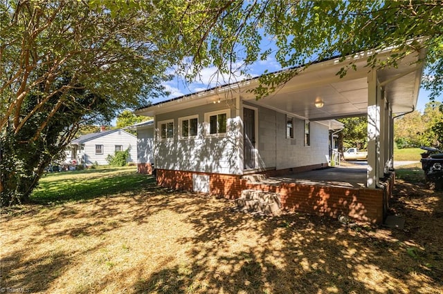 view of property exterior with a yard and a carport