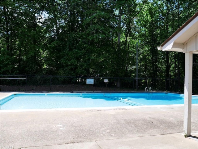 community pool featuring fence and a patio area