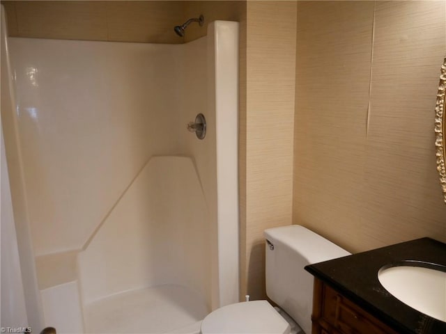 bathroom with vanity, toilet, walk in shower, and tile walls