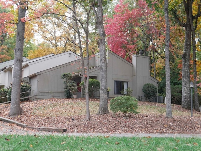 view of side of property featuring a chimney and central AC