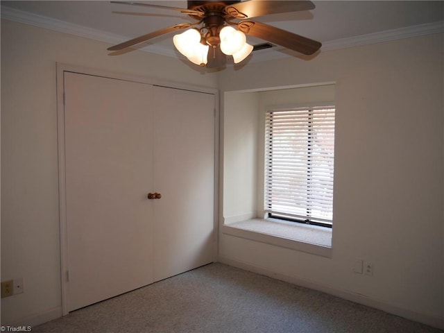 unfurnished bedroom with crown molding, light colored carpet, a closet, and ceiling fan