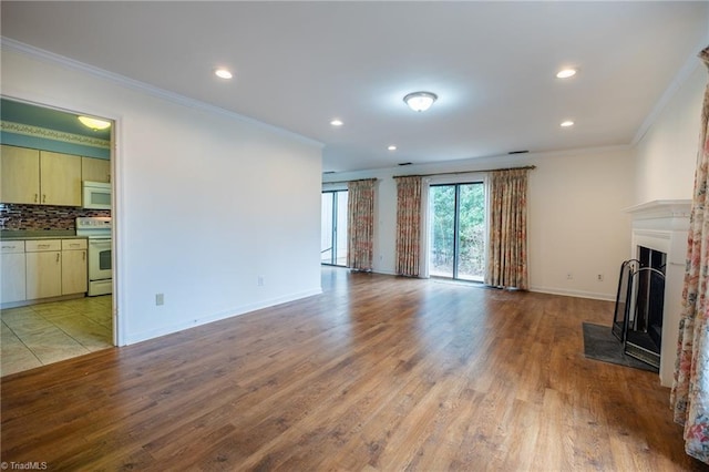 unfurnished living room with a fireplace with flush hearth, light wood finished floors, ornamental molding, recessed lighting, and baseboards