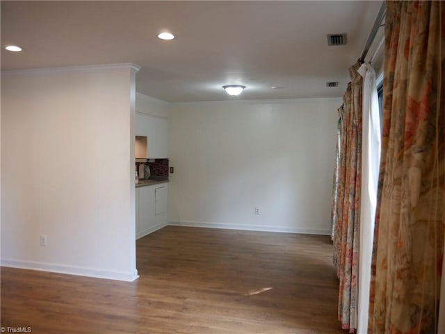 empty room with ornamental molding and hardwood / wood-style floors