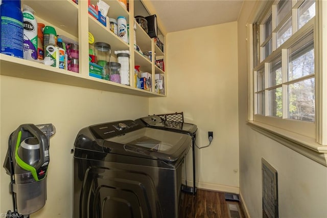 laundry area with laundry area, wood finished floors, washing machine and dryer, and baseboards