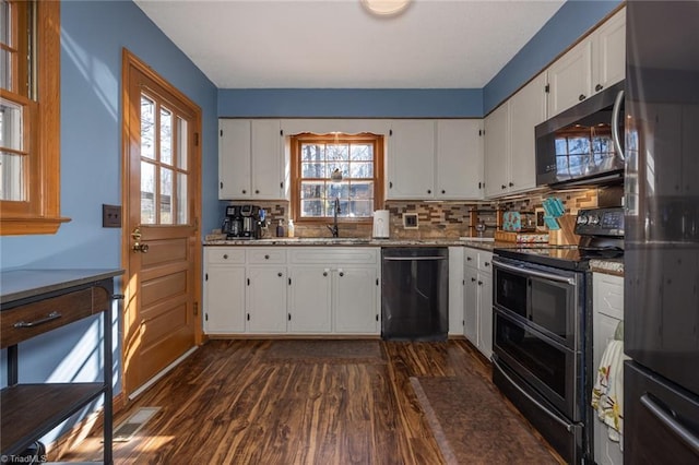 kitchen with light stone countertops, dark wood finished floors, black appliances, white cabinets, and tasteful backsplash