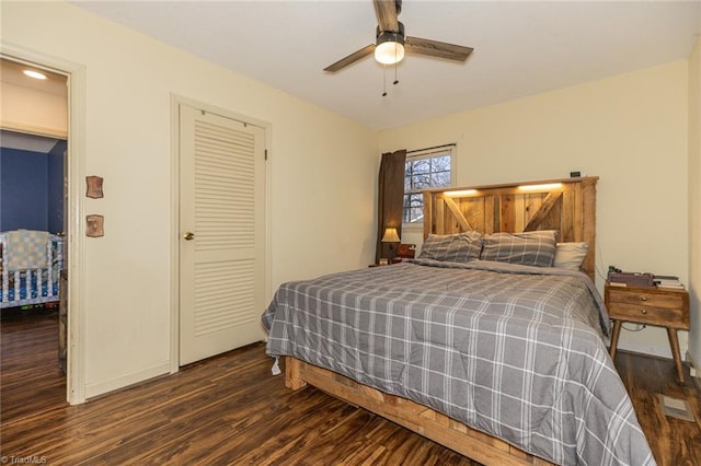 bedroom with visible vents, baseboards, ceiling fan, dark wood-type flooring, and a closet