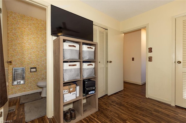 hall with heating unit, baseboards, and dark wood finished floors