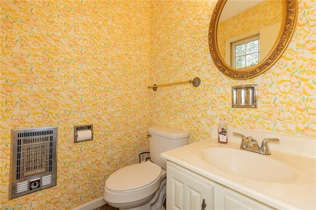 half bath featuring wallpapered walls, toilet, heating unit, and vanity