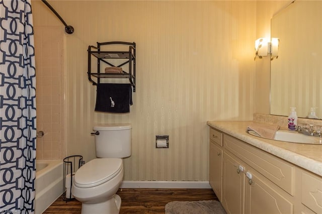 full bath featuring vanity, wood finished floors, baseboards, toilet, and shower / tub combo with curtain