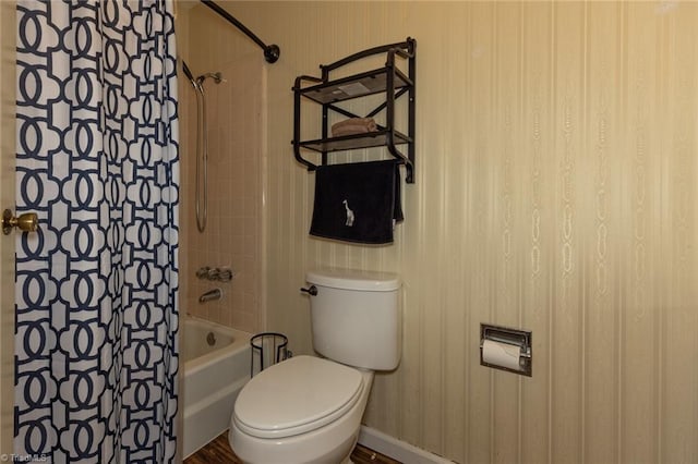 bathroom with baseboards, toilet, shower / tub combo with curtain, and wallpapered walls