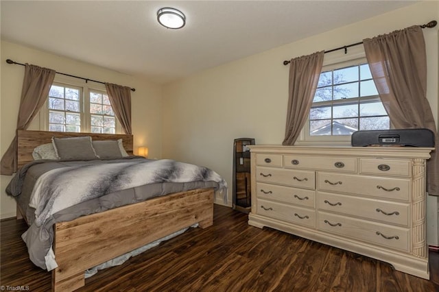 bedroom with multiple windows and dark wood-type flooring