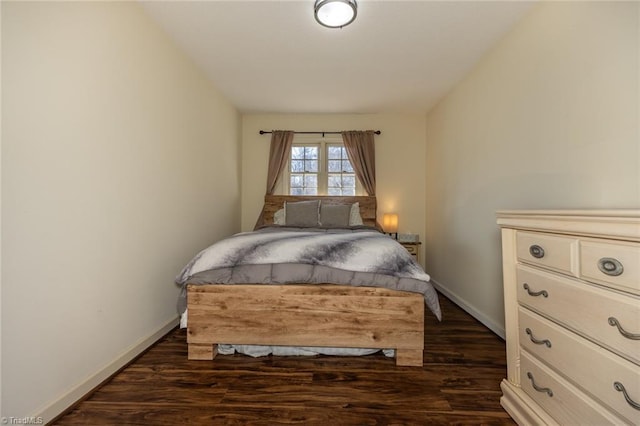 bedroom with dark wood finished floors and baseboards