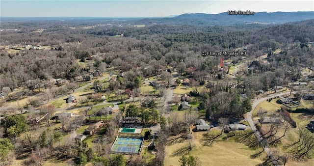 birds eye view of property featuring a mountain view and a wooded view