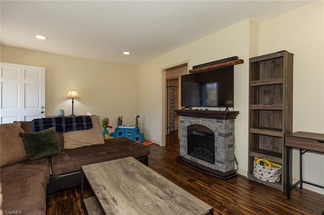 living room with a stone fireplace, recessed lighting, wood finished floors, and baseboards