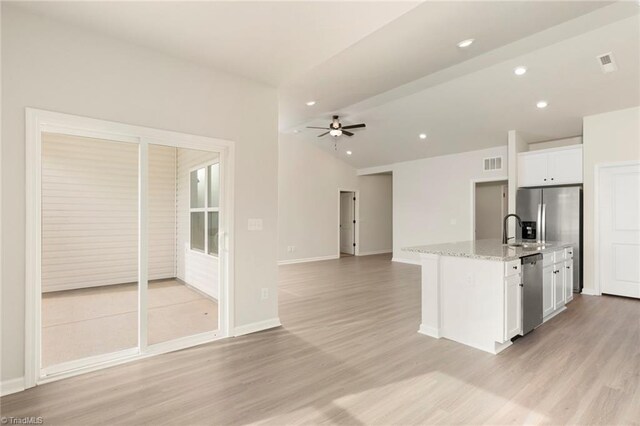 kitchen with vaulted ceiling, stainless steel appliances, ceiling fan, white cabinets, and visible vents