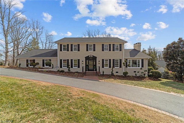 colonial house featuring a front lawn