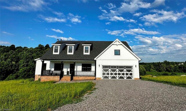 view of front of home featuring a front lawn, a porch, and a garage