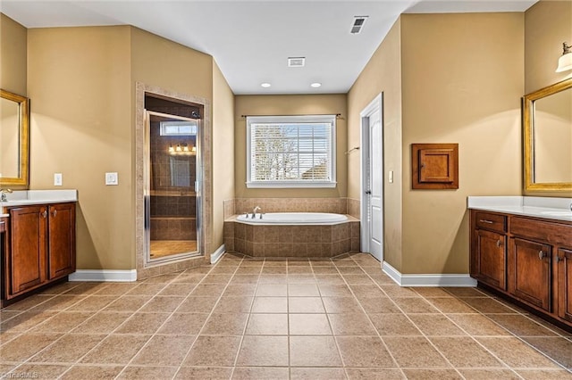 bathroom with vanity, a stall shower, a garden tub, and visible vents