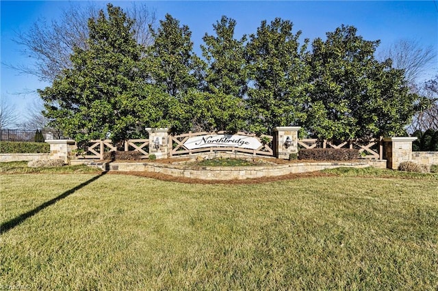 community sign featuring a lawn and fence