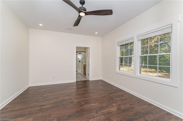 empty room featuring ceiling fan and dark hardwood / wood-style flooring