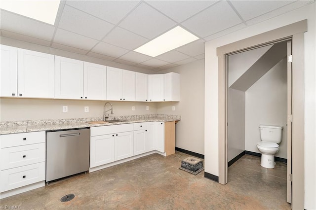 kitchen featuring white cabinetry, a drop ceiling, dishwasher, and sink